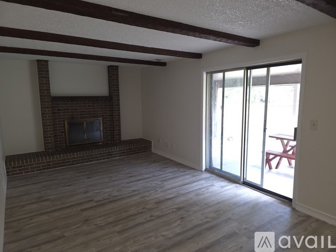 A room with a fireplace and sliding glass doors.