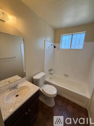 A bathroom with a toilet, sink, and bathtub.