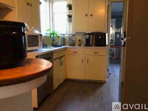 A kitchen with white cabinets and a wooden counter.