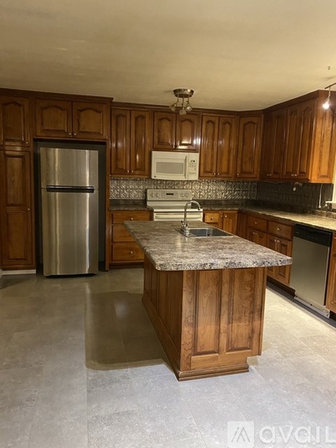 A kitchen with wooden cabinets and a granite countertop.