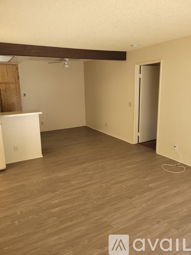 A room with wooden flooring and a white cabinet.