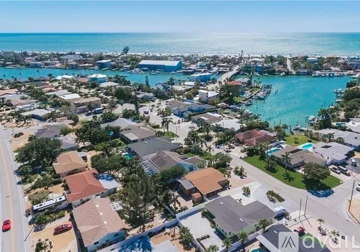 A bird's eye view of a residential area with houses, roads, and a body of water.