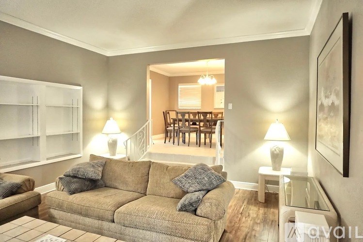 A living room with a couch, a chair, and a painting on the wall.