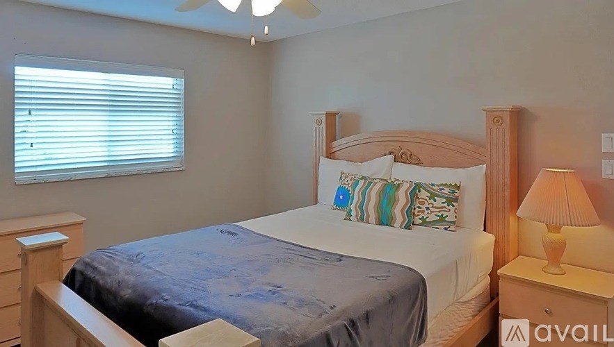 A bedroom with a bed, nightstand, and lamp.