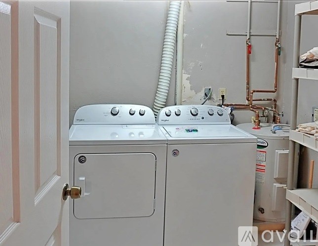 A white washing machine sits in a laundry room.