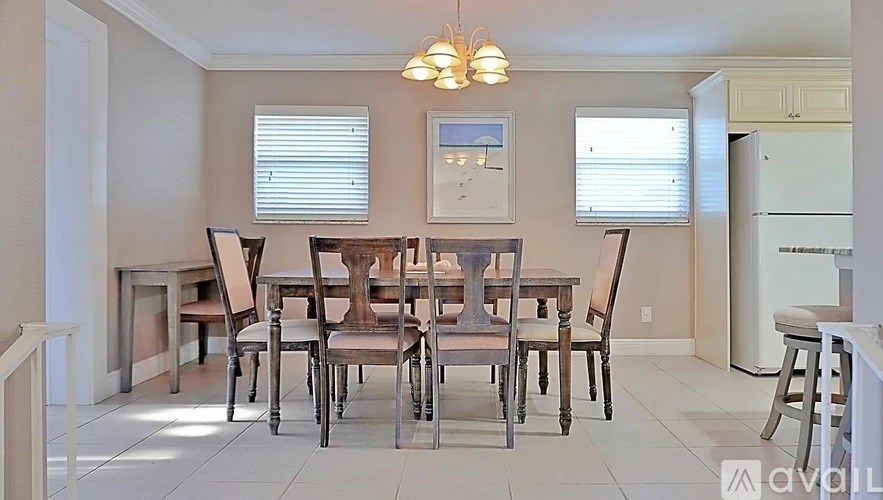 A dining room with a table and chairs.
