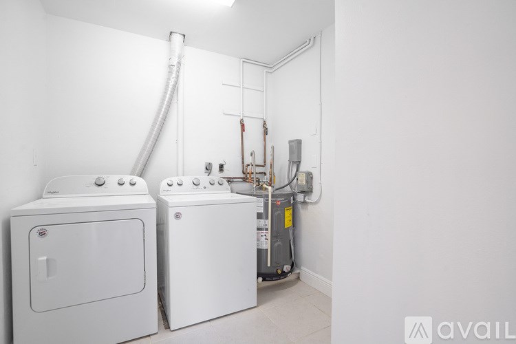 A white dryer and washing machine in a laundry room.