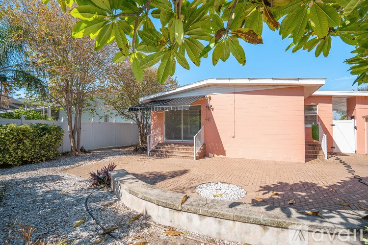 A house with a pink exterior and a gravel driveway.