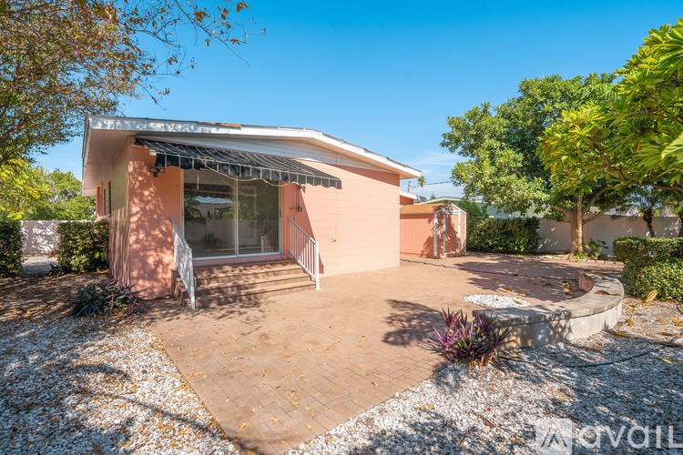 A house with a patio and a gravel area in front.