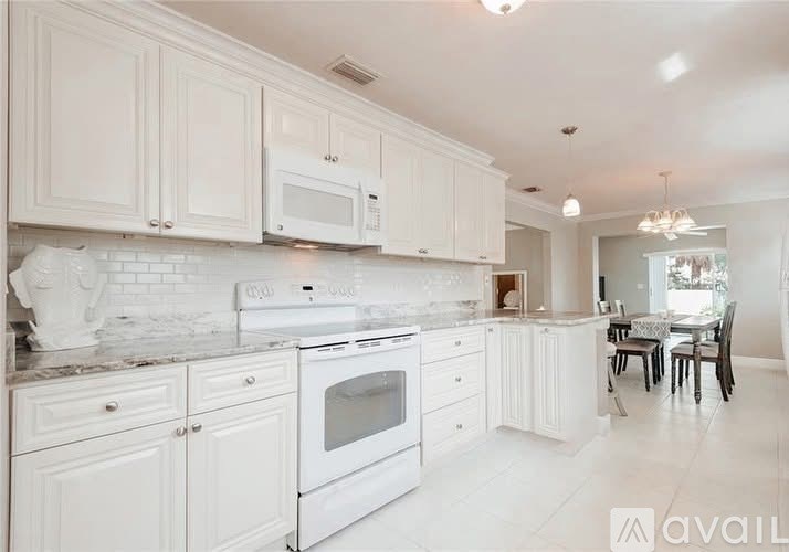 A white kitchen with a dining table and chairs.