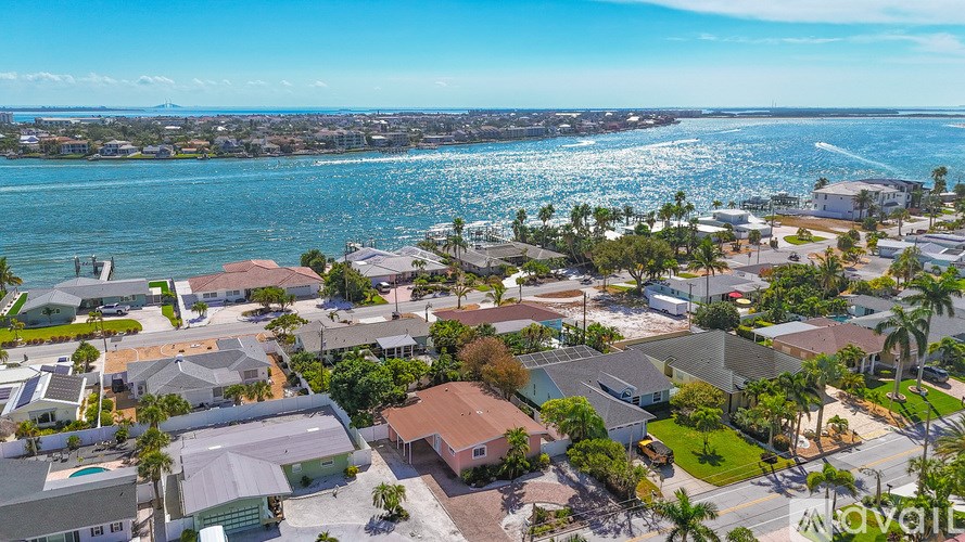 A bird's eye view of a residential area with houses and a body of water.