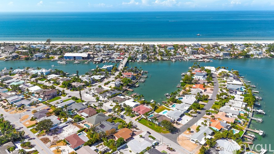 A bird's eye view of a coastal residential area with houses and boats.