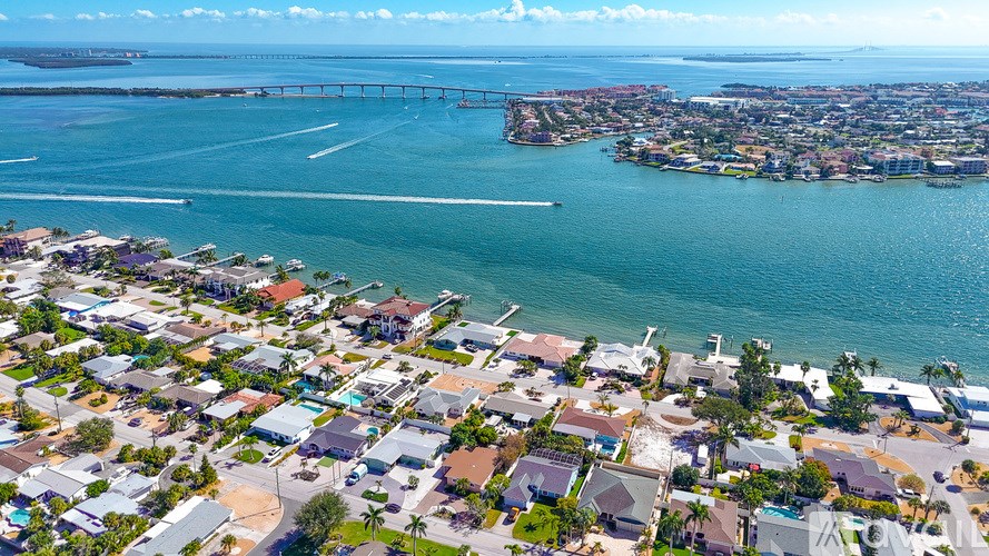 A bridge spans the waterway in front of a densely built coastal area.