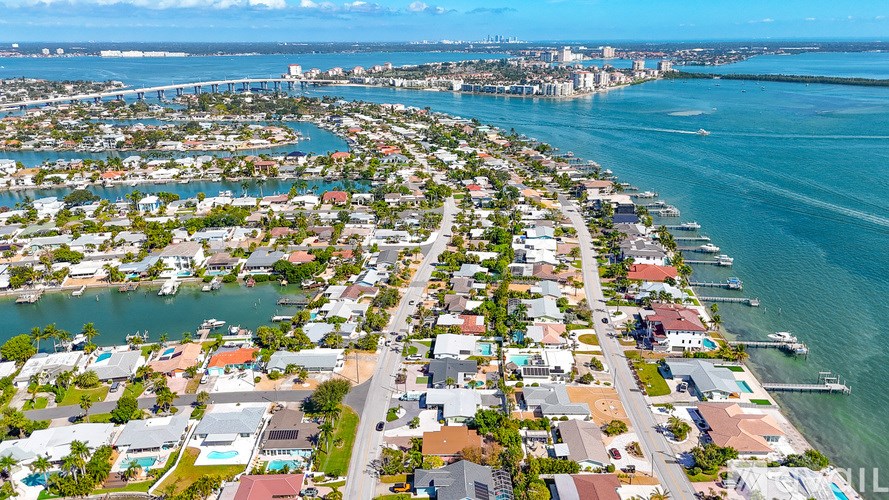 A coastal city with a long waterfront and a bridge in the distance.
