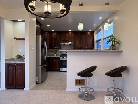 A kitchen with dark wood cabinets and a white countertop.