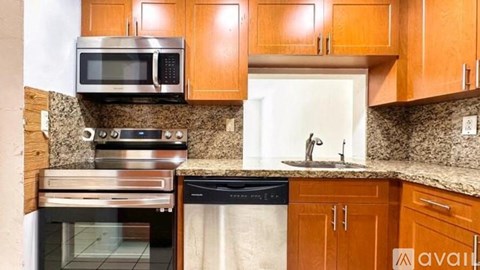 A kitchen with wooden cabinets and a granite countertop.