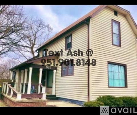 A house with a porch and a phone number on it.