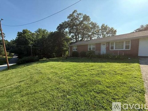 A backyard with a green lawn and a house in the background.