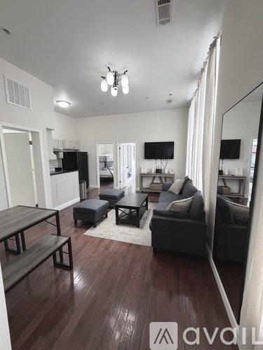 A bedroom with a bed, desk, and mirror.