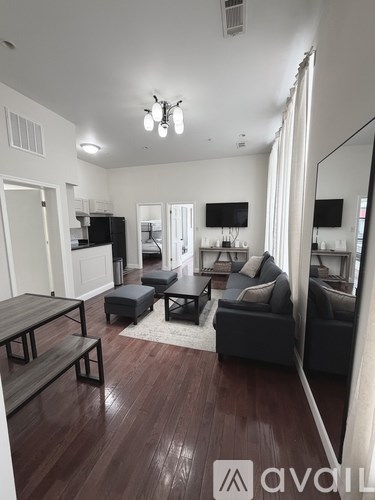 A bedroom with a bed, desk, and mirror.