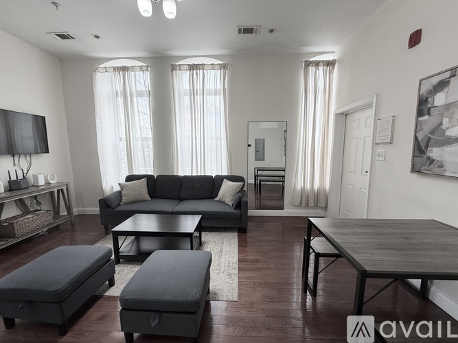 A bedroom with a bed, desk, and two doors.