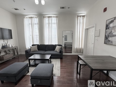A bedroom with a bed, desk, and two doors.