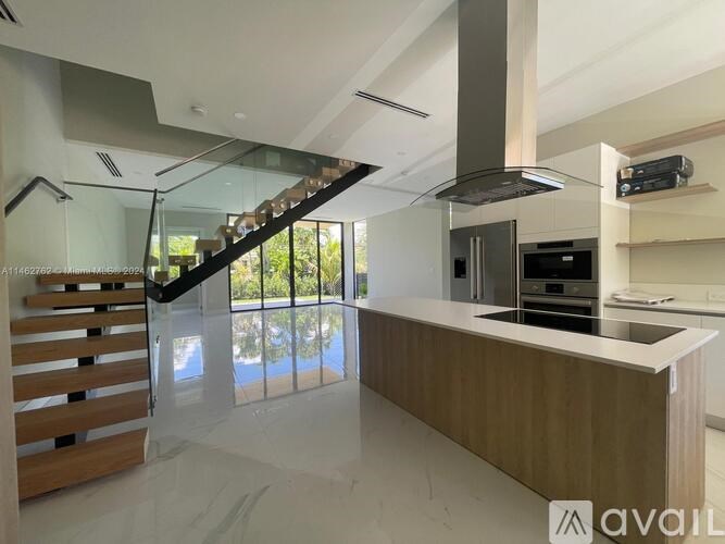 A modern kitchen with a wooden counter and stainless steel appliances.