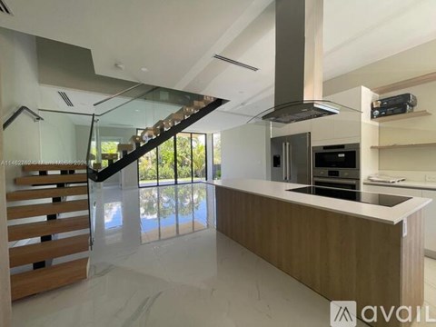 A modern kitchen with a wooden counter and stainless steel appliances.