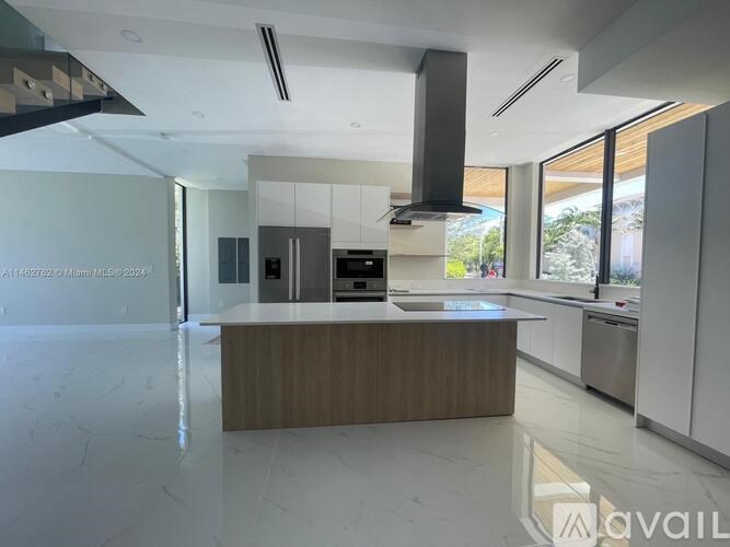 A modern kitchen with a wooden island in the middle.