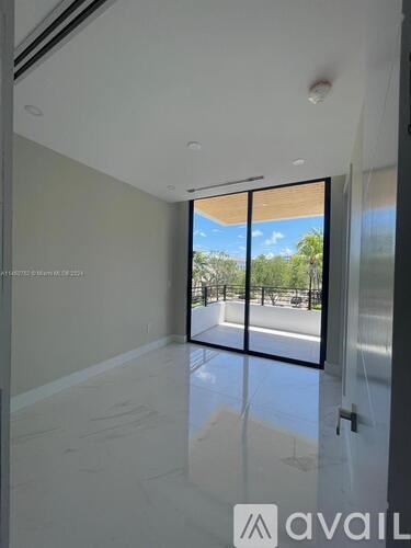 A room with a sliding glass door leading to a balcony.