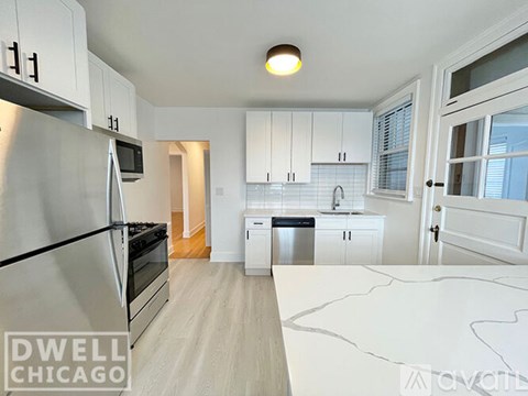 A modern kitchen with white cabinets and a stainless steel refrigerator.