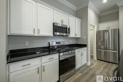 A kitchen with white cabinets and stainless steel appliances.