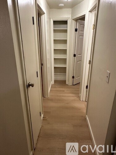 A hallway with a staircase and a door on the right.