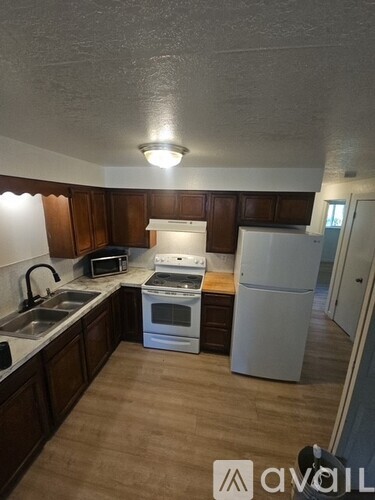 A kitchen with wooden cabinets and white appliances.