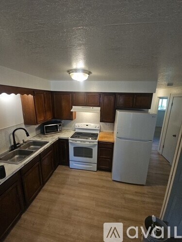 A kitchen with wooden cabinets and white appliances.