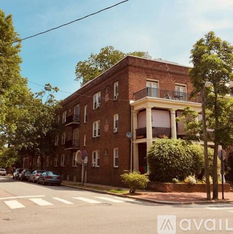 A red brick building with a balcony on the second floor.