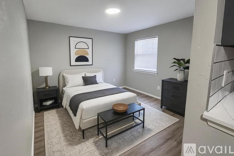 A room with a white door and a kitchenette with a sink and stove.