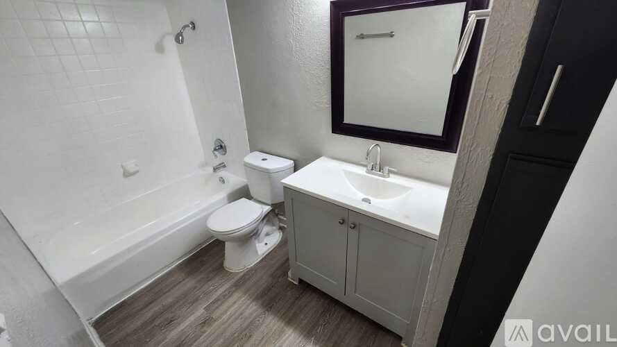 A bathroom with a white toilet, sink, and bathtub.