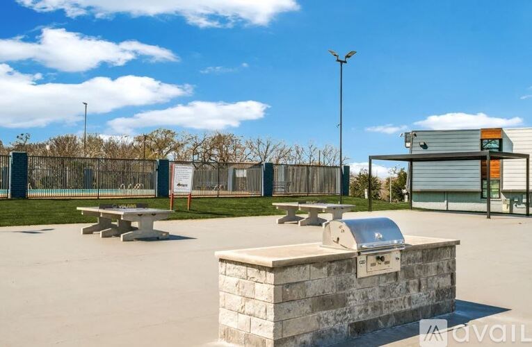 A park with picnic tables and a grill area.