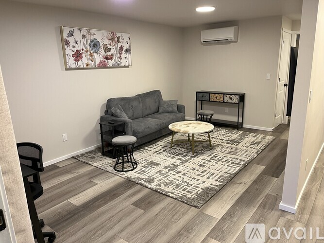 A living room with a grey couch, a coffee table, and a rug.