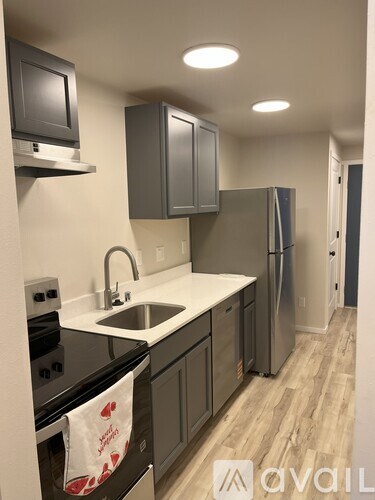 A kitchen with a black stove top oven and a white sink.