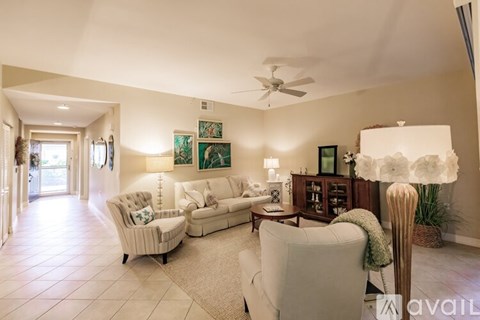A living room with a white sofa set and a large floor lamp.