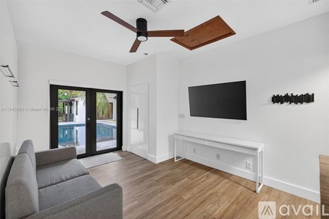 A living room with a grey sofa and a television mounted on the wall.