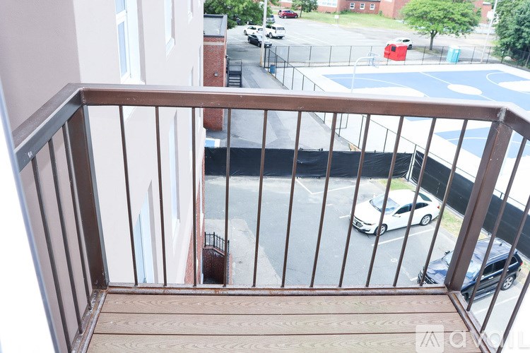 A balcony view of a street with cars and buildings.