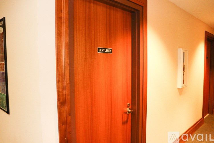 A wooden door with a sign that says "Gentlemen" on it.