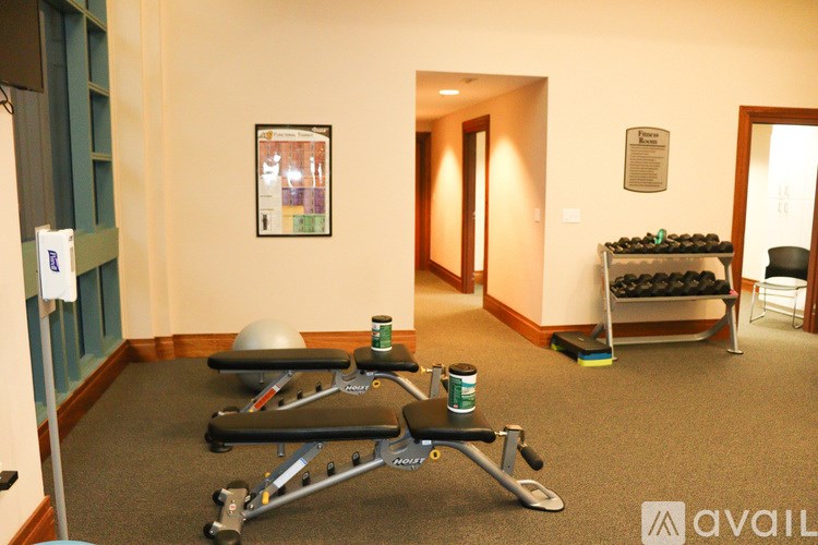 A room with pilates equipment and a bench with weights.