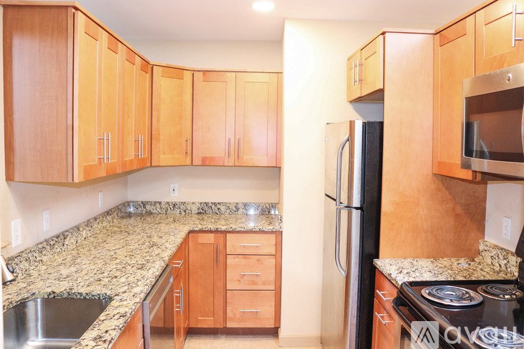 A kitchen with wooden cabinets and granite countertops.