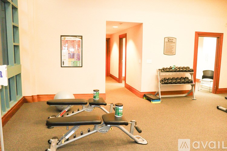 A gym room with exercise equipment and a bench.
