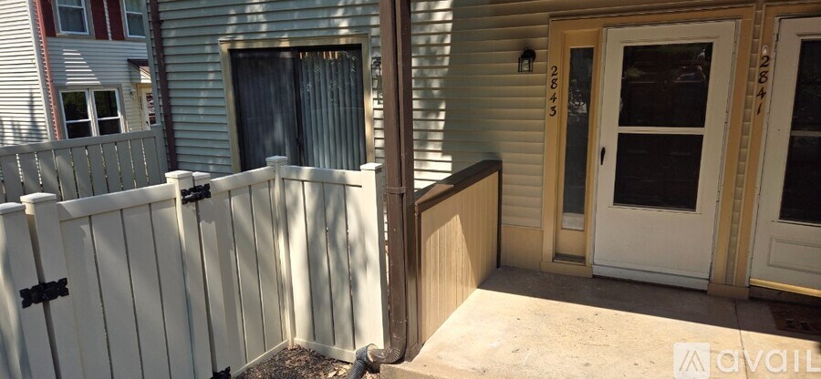 A white picket fence surrounds a small porch area.