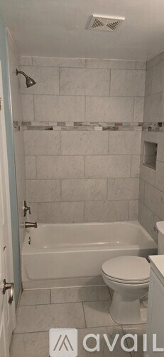 A bathroom with a white toilet and a white bathtub.